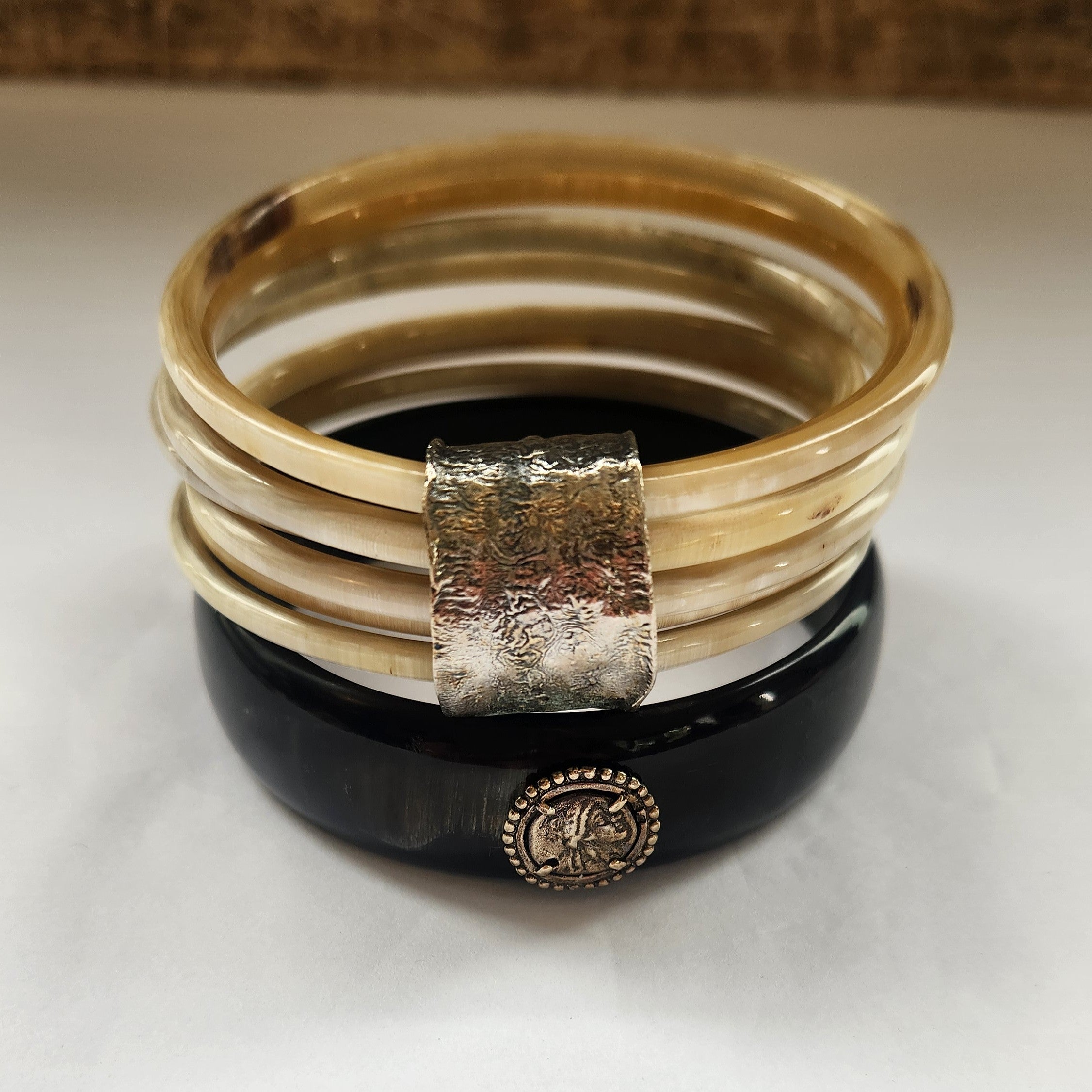 Stack of bangles with a black base and silver accents on a white background