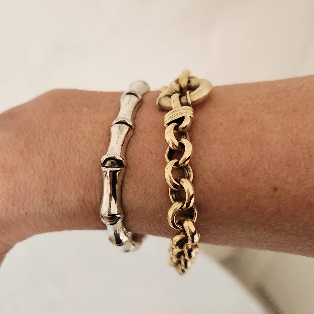 Sterling Silver bracelet on wrist along with gold bracelet