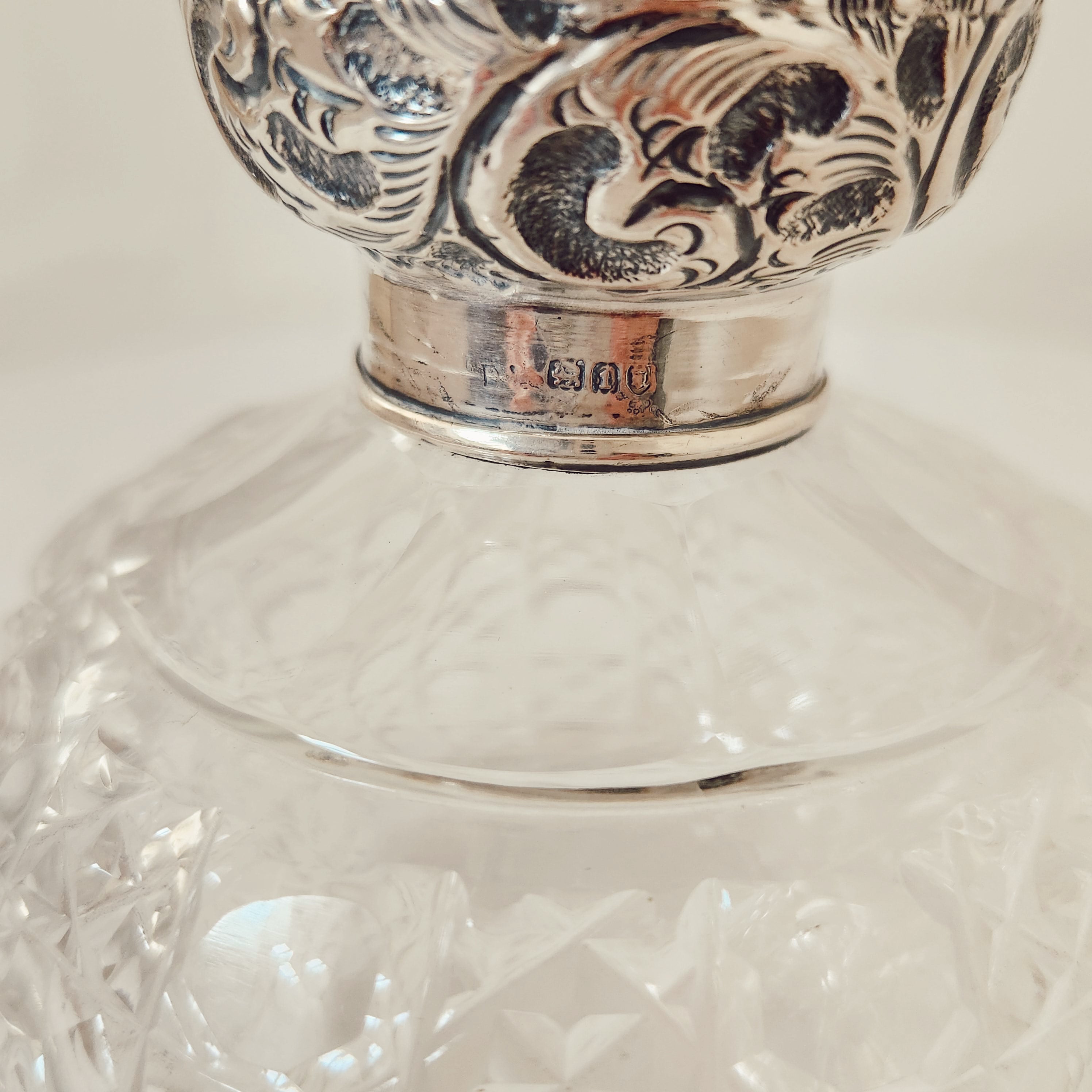 A Vintage Pair of Profusely Cut-Glass Perfume Bottles with silver plated stoppers and ‘Louise’ Engraved on the lids.