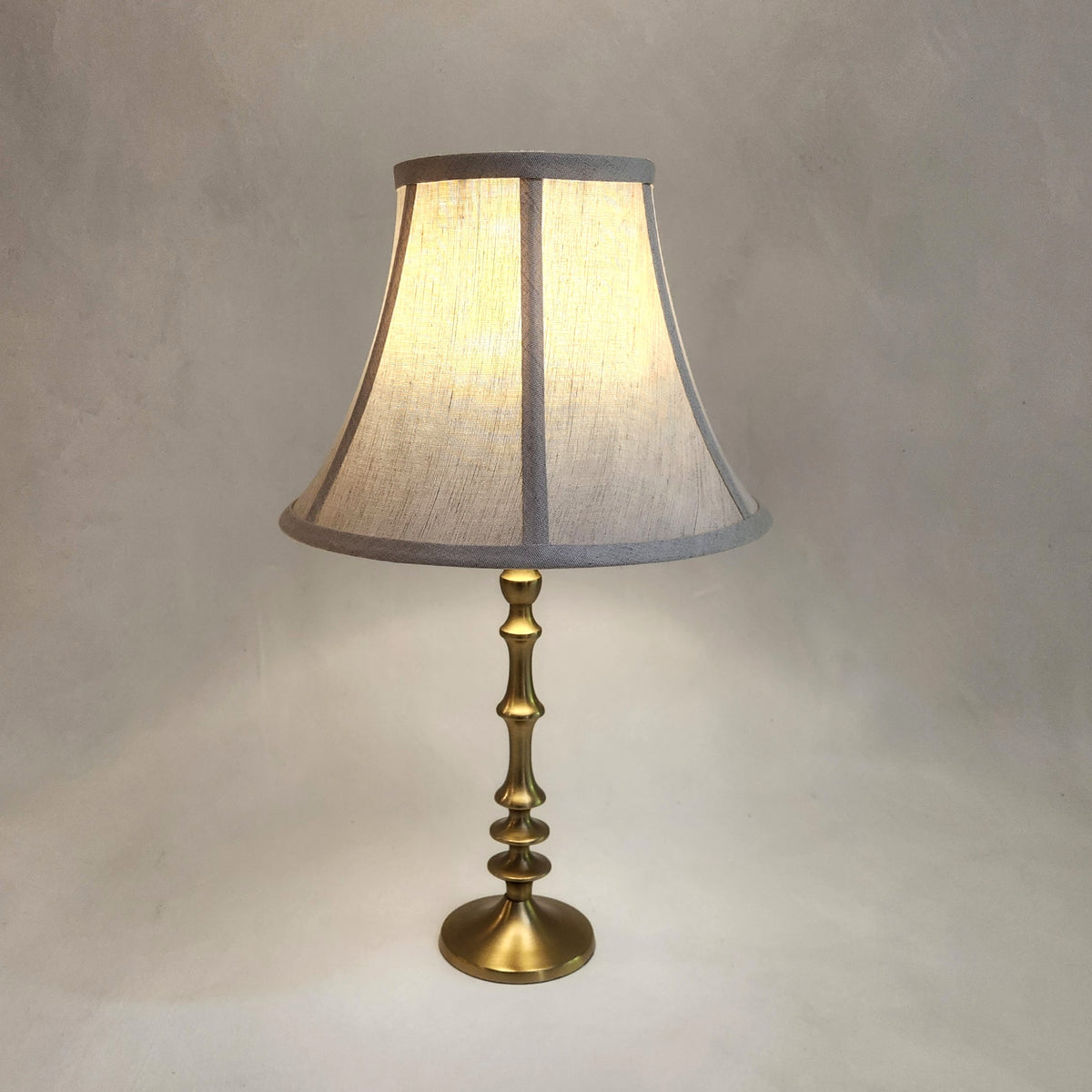 waisted linen lampshade on brass base