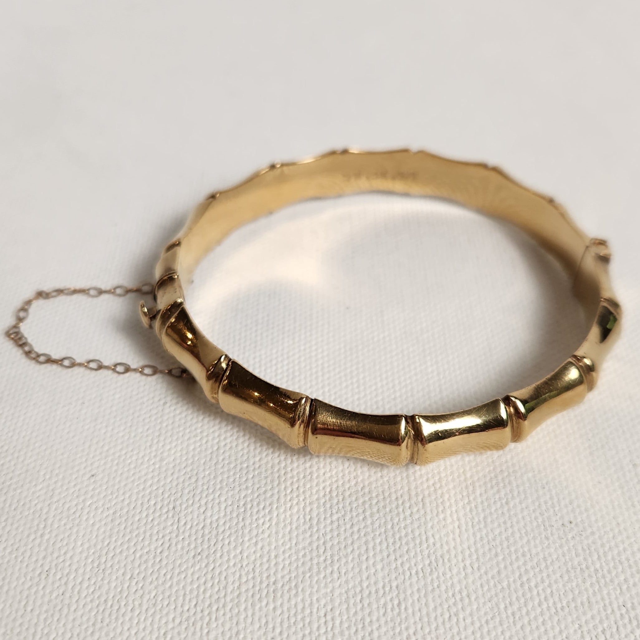 Gold bracelet with chain on a light gray background