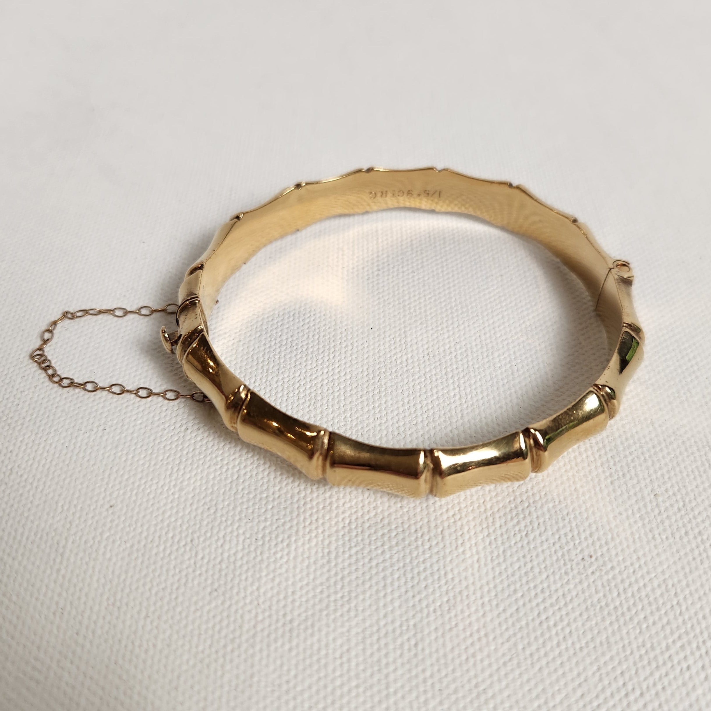 Gold bracelet with chain on a light gray background