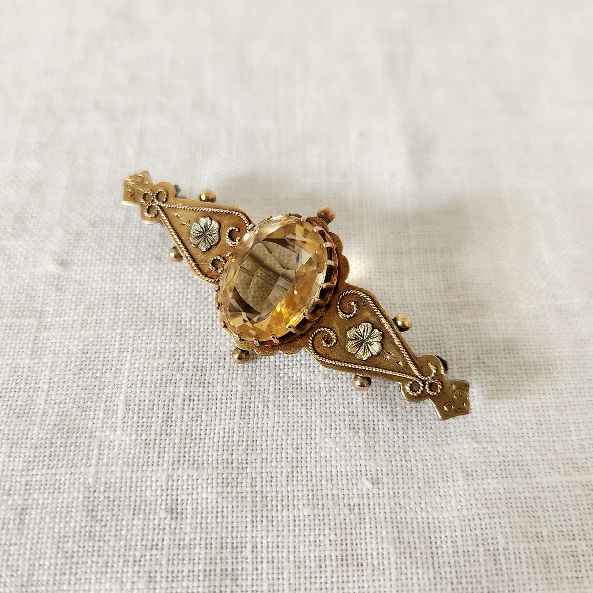 Antique Citrine Brooch on linen fabric background