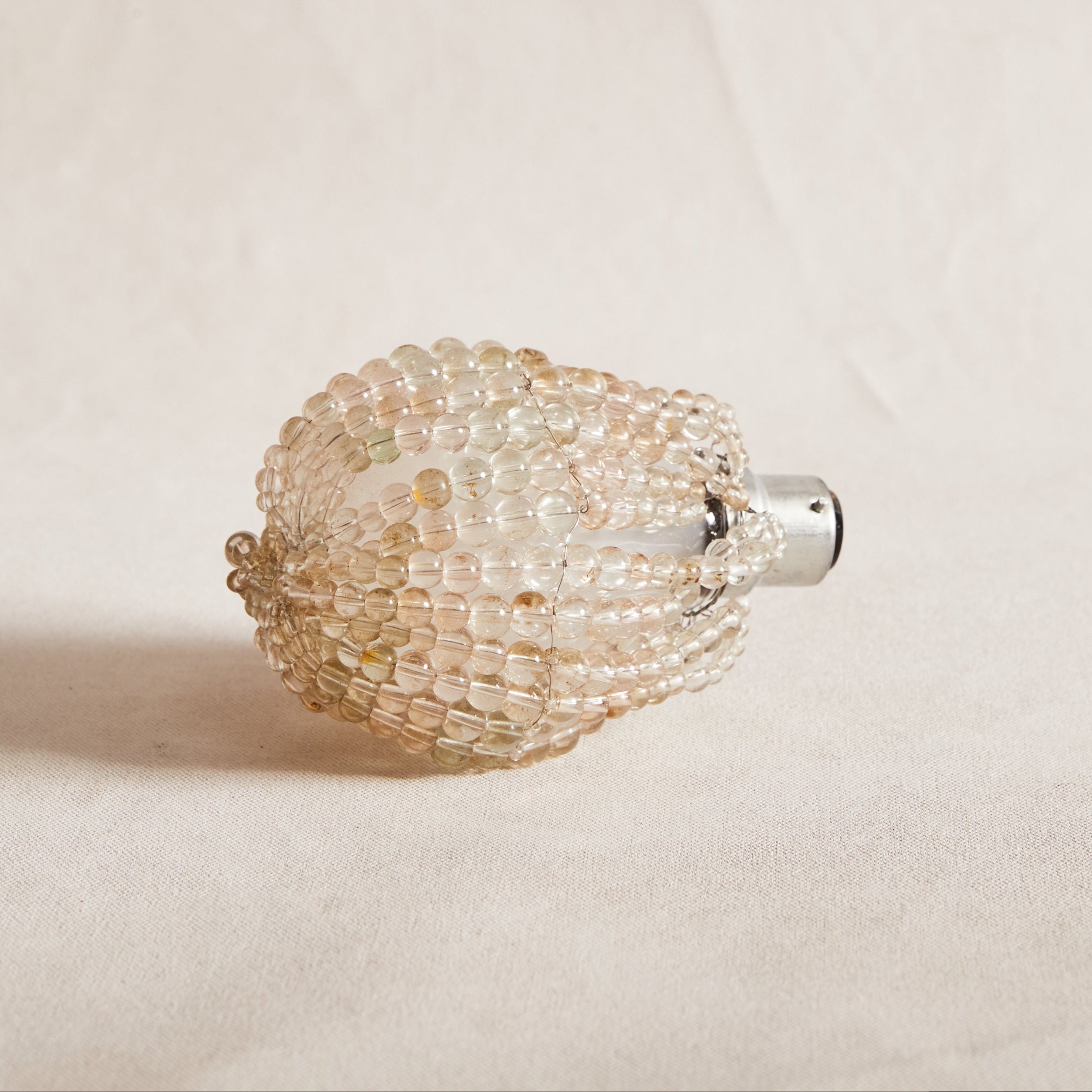 A glass beaded bulb cover designed to fit on a light globe, displayed against a neutral background.