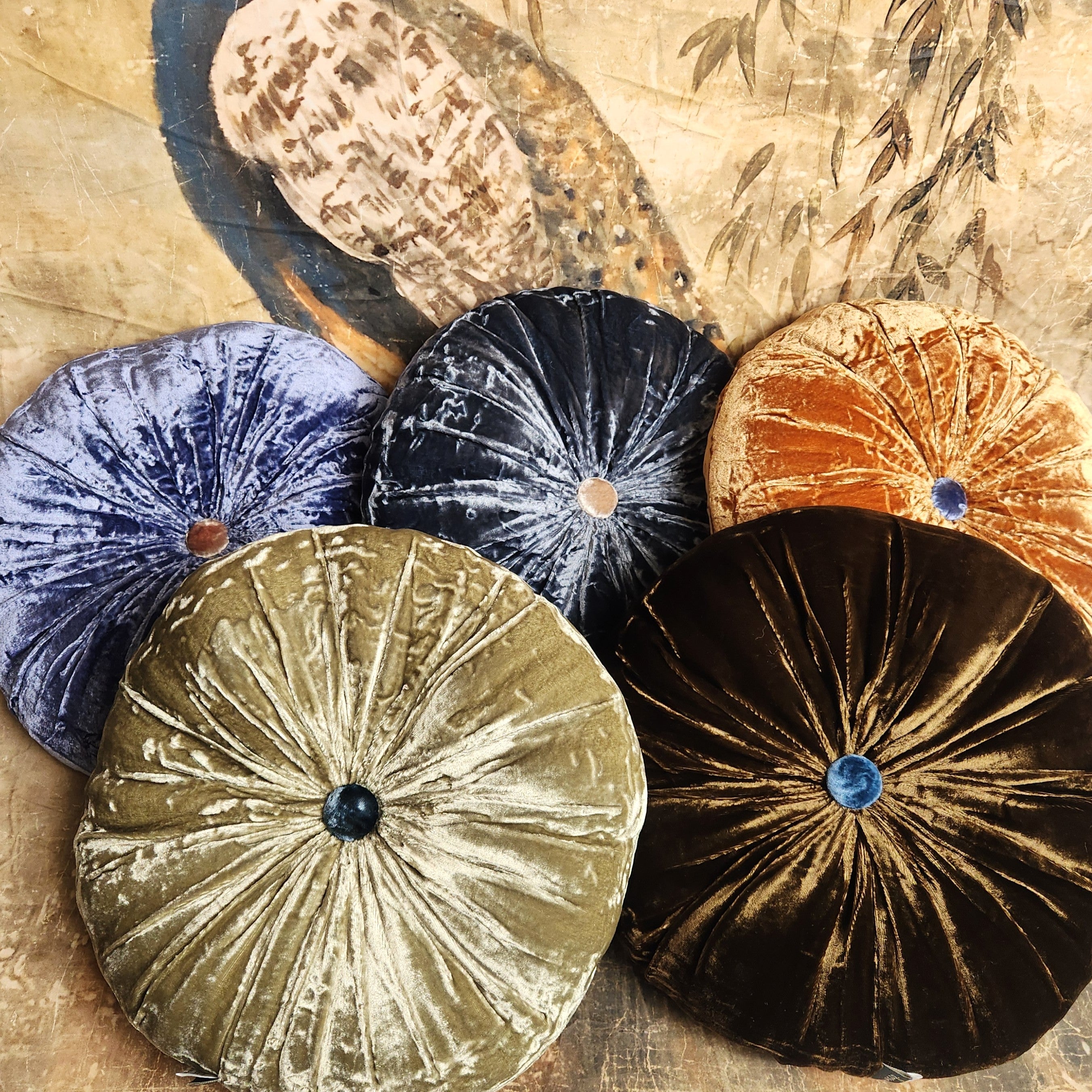 Display of lush silk velvet cushions on peacock background
