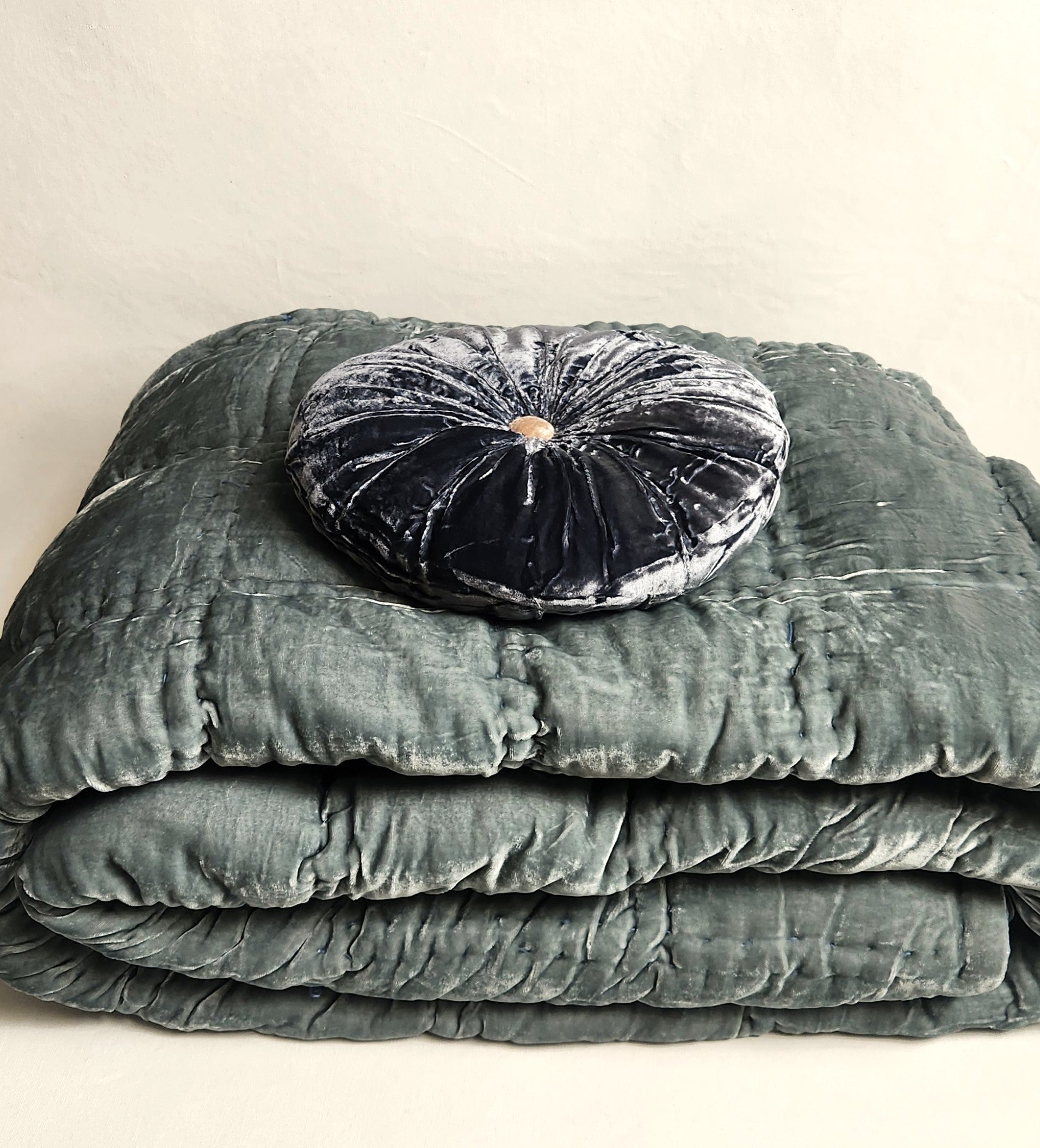 Smoky blue silk velvet round cushion on green blue silk velvet quilt