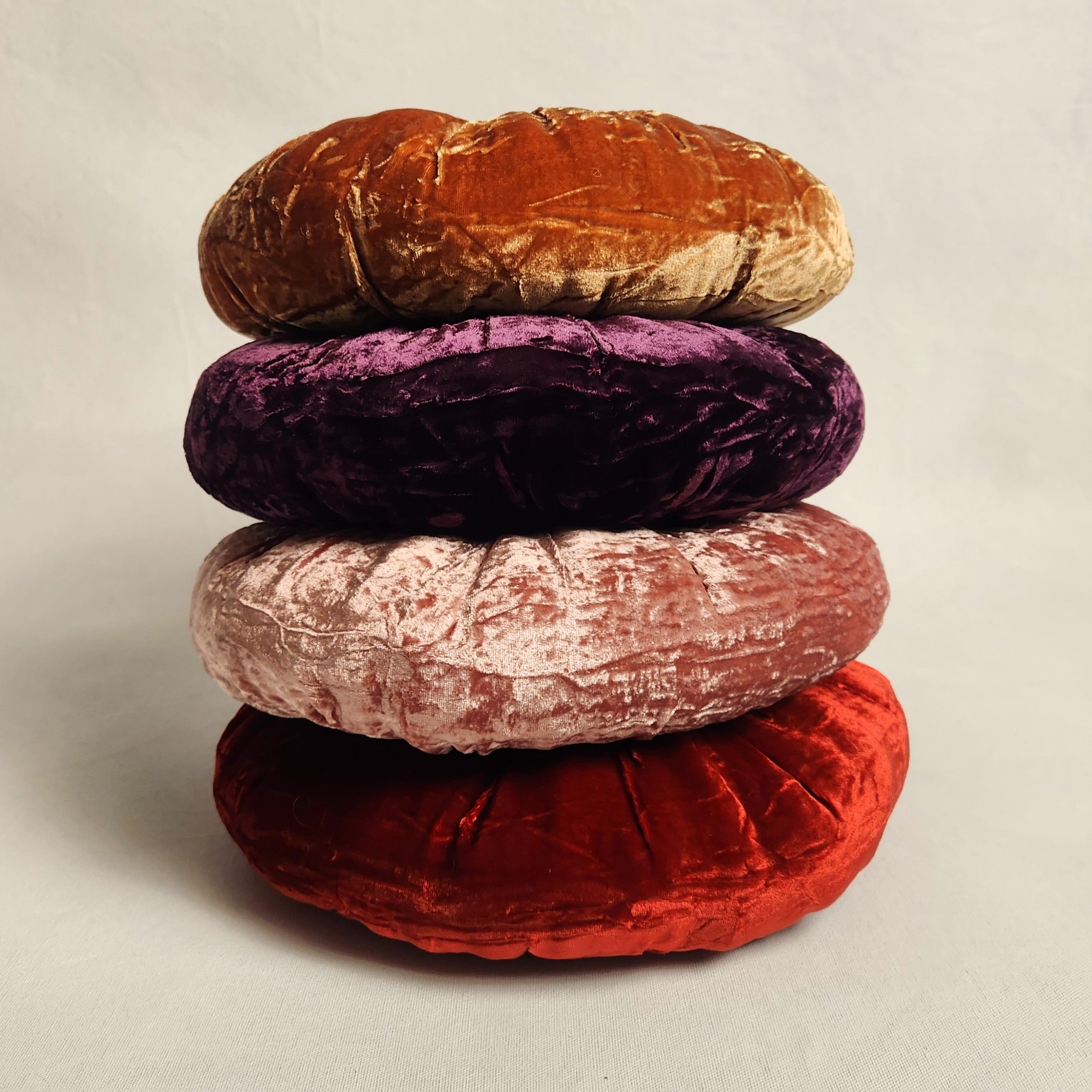 Stack of round silk velvet cushions