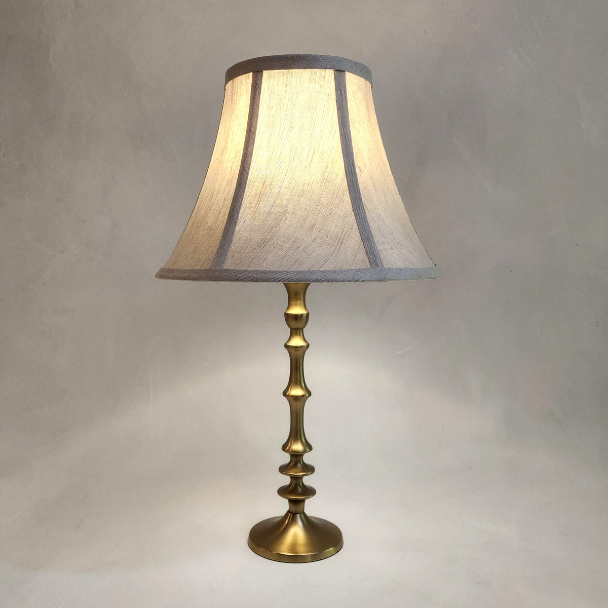 waisted linen lampshade on brass base