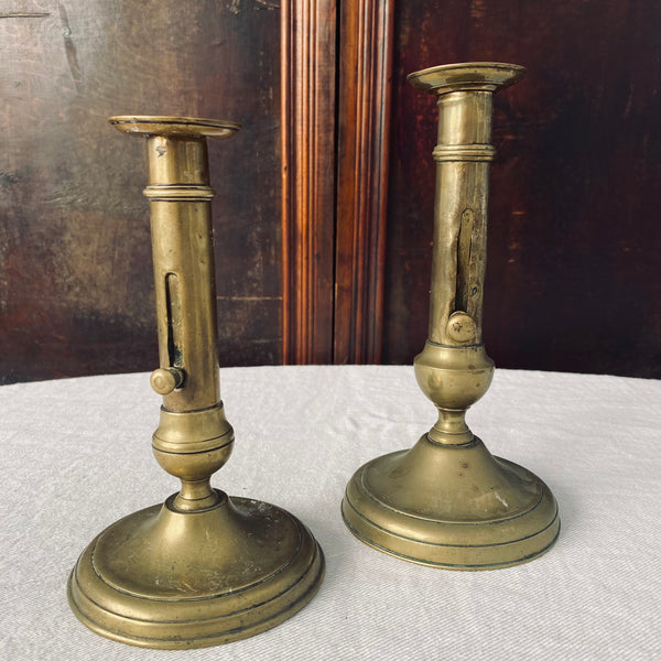 Pair of Antique French Brass Ejector Candlesticks, varied heights
